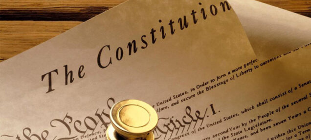 The Constitution written out on paper on a wooden table